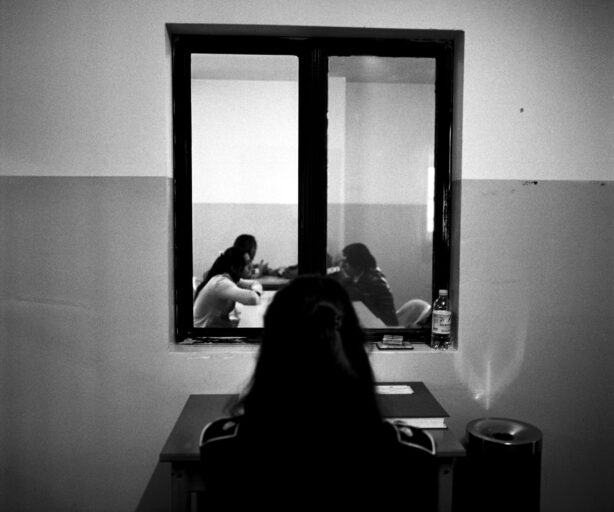 Un'agente della polizia penitenziaria controlla un colloquio tra detenute e parenti nella Casa circondariale Dozza di Bologna (Foto di Francesco Cocco/Contrasto).